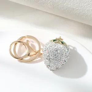 Detailed close-up of sparkling rhinestone strawberry keychain with polished gold hardware