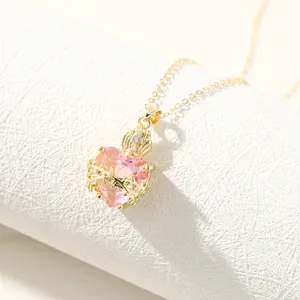 Detailed macro view of pink heart pendant necklace with gold thorn wrap and crown