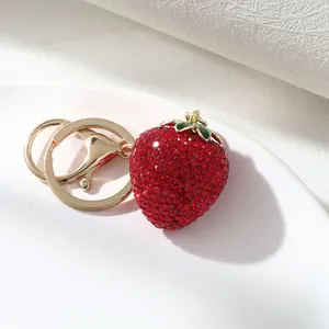 Close-up of sparkling red rhinestone strawberry keychain with gold clasp