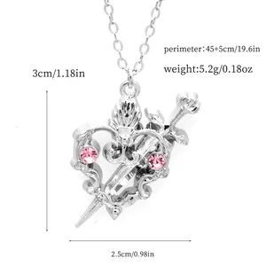 Detailed view of silver heart pendant with pink crystals and sword motif