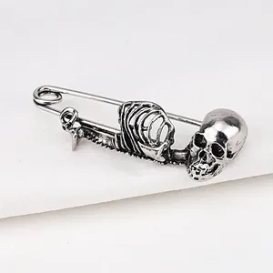 Gedetailleerde close-up van een vintage zilveren schedel en skelet veiligheidsspeld broche