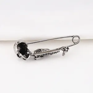 Detailweergave van een vintage punk stijl zilveren schedel en ruggengraat broche