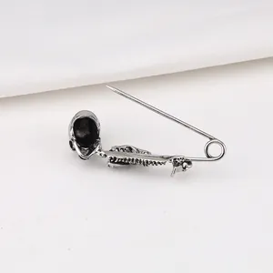 Gedetailleerd vooraanzicht van punk gothic schedel veiligheidsspeld broche in antiek zilver.