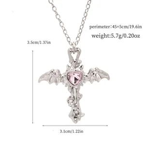 Detailed view of silver bat-wing cross necklace with pink heart gem and dimensions