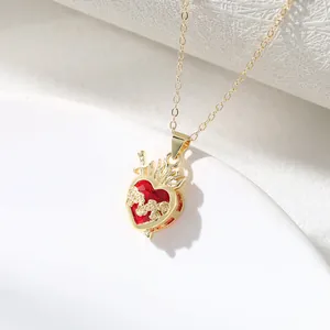 Close-up detail of crown heart necklace with rose vines and sword, luxury gold finish.