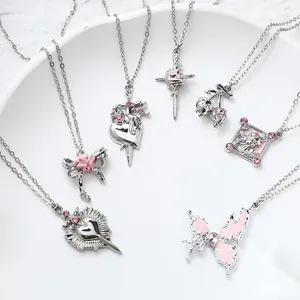 Close-up of various silver and pink pendants including heart, cross, and butterfly