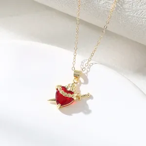 Macro detail of elegant gold-tone heart necklace with sword and crown pendant jewelry
