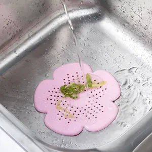 Pink flower-shaped silicone sink strainer and drain cover in a stainless steel sink
