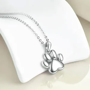 Close-up of a silver stainless steel pet paw print cremation necklace for ashes