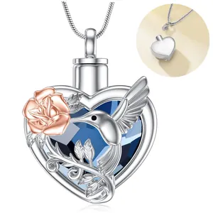 Detail showing the heart urn pendant with blue crystal, rose gold flower, and hummingbird.
