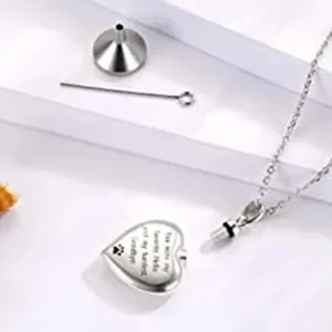 Detail of heart pet cremation urn necklace with paw print and funnel tool kit.