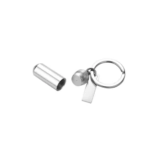 Open view of a stainless steel cylindrical pill bottle keychain with tag