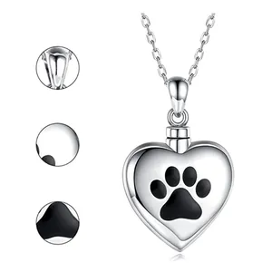 Close-up detail of stainless steel heart urn necklace with black paw print design