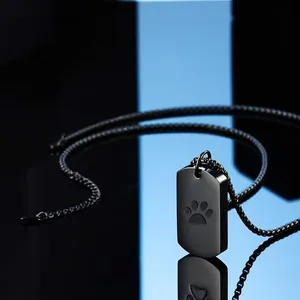 Detailed close-up view of black rectangular cremation urn necklace with engraved paw print