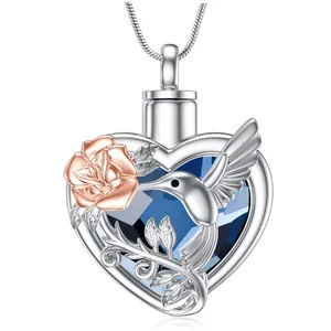 Detailed view of silver heart urn necklace with rose gold rose and hummingbird