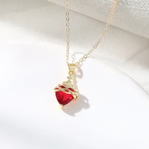 Elegant gold chain necklace with red heart gemstone pendant featuring a crown and thorns.