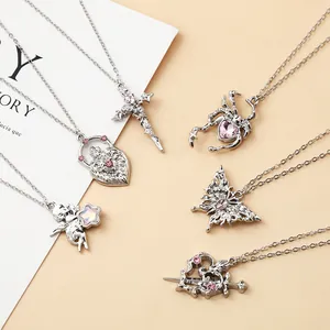 Close-up of silver-toned alloy necklaces featuring pink crystals in heart and cross designs