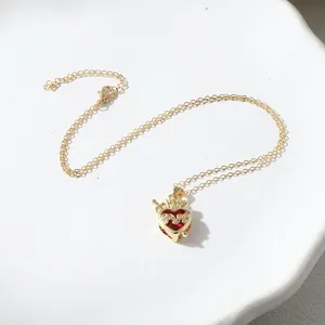 Close-up of crown heart pendant necklace with red gemstone and sword detail