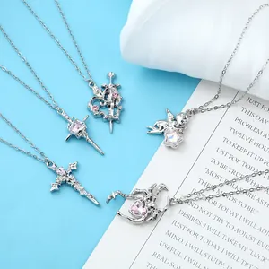 Various silver necklaces with pink crystals in heart, cross, and angel designs.
