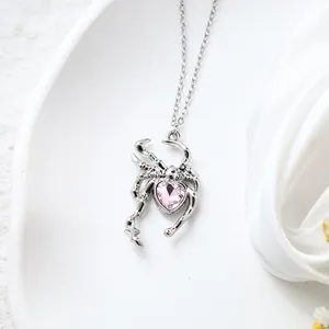 Detailed view of gothic spider pendant featuring a pink heart-shaped crystal inlay.