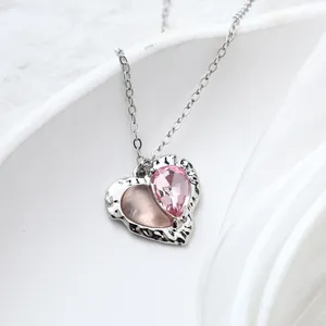 Detail shot of a sweet pink heart pendant necklace with shimmering teardrop crystal
