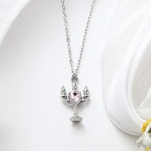 Close-up detail of a silver-tone necklace with a pink heart-shaped crystal pendant