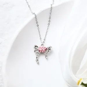 Detailed macro view of an elegant pink rose bow pendant on a silver chain necklace