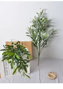 Detail view of artificial olive branch with realistic green leaves and dark fruits