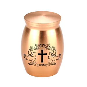 Close-up detail of small rose gold aluminum urn featuring cross and dove engraving