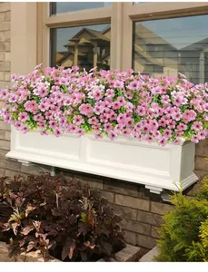Wunderschöne lebendige rosa Kunstblumen blühen in einem weißen Fensterkasten im Freien.