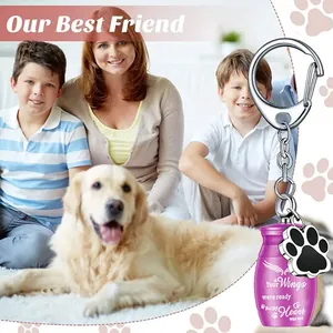 Close-up of a purple pet memorial urn keychain with engraved wings and paw charm.