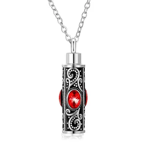 Detalle del colgante de urna conmemorativo en plata vintage con gema roja y filigrana
