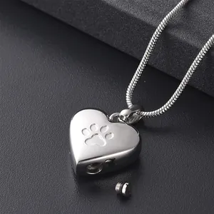 Close-up of a heart-shaped stainless steel pet cremation urn necklace with paw print detail