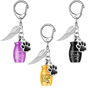 Three pet cremation urn keychains with angel wings and paw charms in various colors.