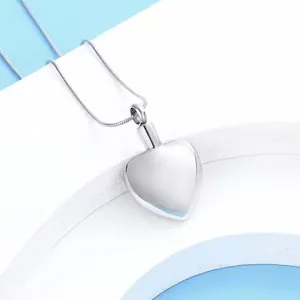Gros plan détaillé d'un pendentif en forme de cœur argenté pour cendres funéraires