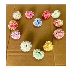 Multi-color artificial chrysanthemum silk flower heads in a heart shape on brown cardboard