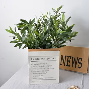 Artificial olive branches with fruits in a decorative French paper bag for home decor