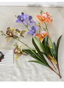 Detail of lifelike artificial Cattleya orchids with 4 heads and green leaves
