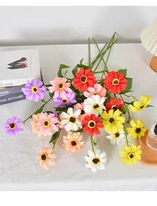 Bunte künstliche Gänseblümchen, wunderschön arrangiert auf einer weißen strukturierten Tischplatte