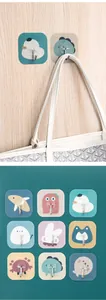 Close-up detail of cute cartoon animal adhesive wall hooks for home organization.