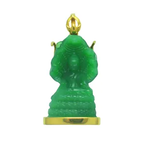 Detail van een groene doorschijnende Naga Boeddha-hanger met een gouden voetstuk.