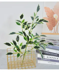 Vue détaillée d'une branche de ficus artificielle dans un panier en fil doré