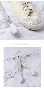 Macro view of double-headed shoe brush with soft bristles for cleaning canvas sneakers