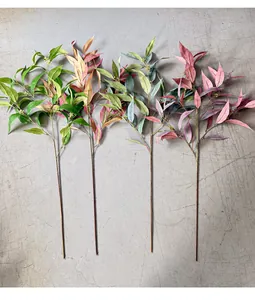 Detail of four different colored artificial eucalyptus branches on a grey background