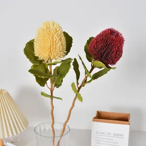 Pair of realistic yellow and red artificial Banksia flowers in a glass vase for home decor