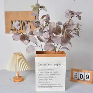 Artificial eucalyptus branches with berries in stylish paper bag vase for home decor