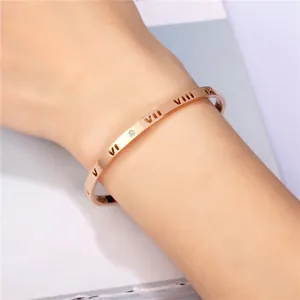 Nahaufnahme eines Armreifs in Roségold mit hohlen römischen Ziffern und Kristallbesatz
