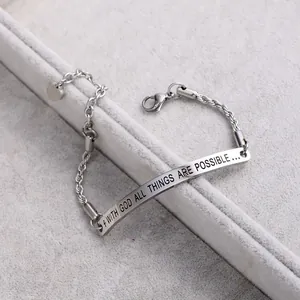 Close-up of 'WITH GOD ALL THINGS ARE POSSIBLE' engraving on silver chain bracelet.