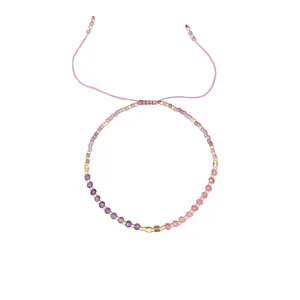 Detailed macro view of Morse code beaded bracelet with pink and purple natural stones.