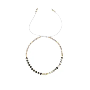 Detailed view of a minimalist Morse code beaded bracelet with adjustable white cord.